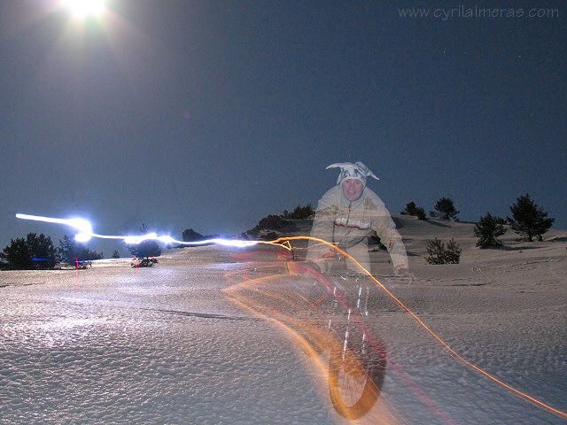 Traces lumineuses en VTT sur neige de nuit