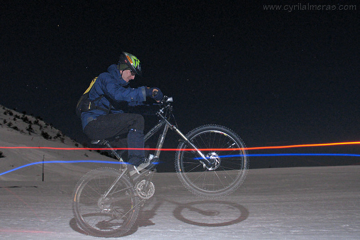 Wheeling mountain bike by night on snow