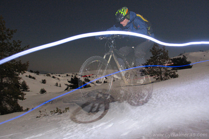 Mountain bike jump on snow by night